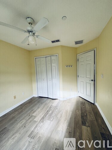 A room with a ceiling fan and two doors.