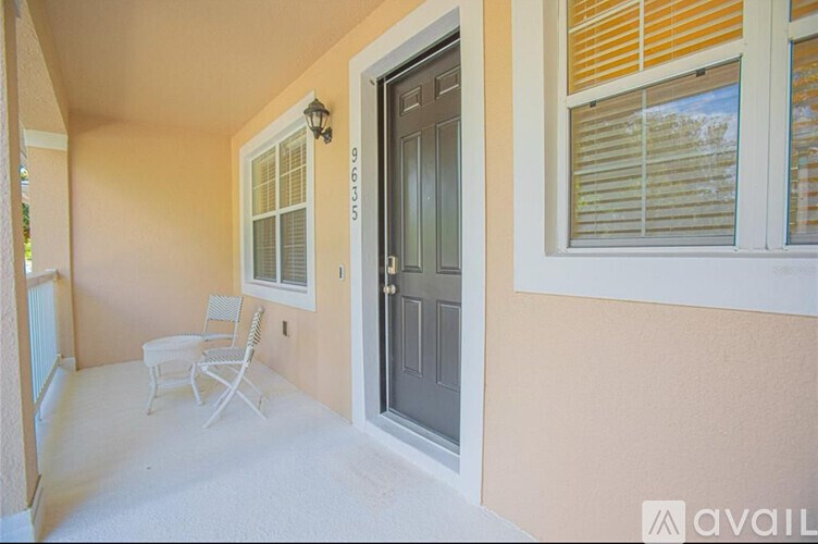 A patio with a chair and a door.