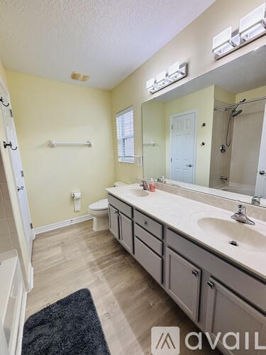 A bathroom with a sink, mirror, and toilet.