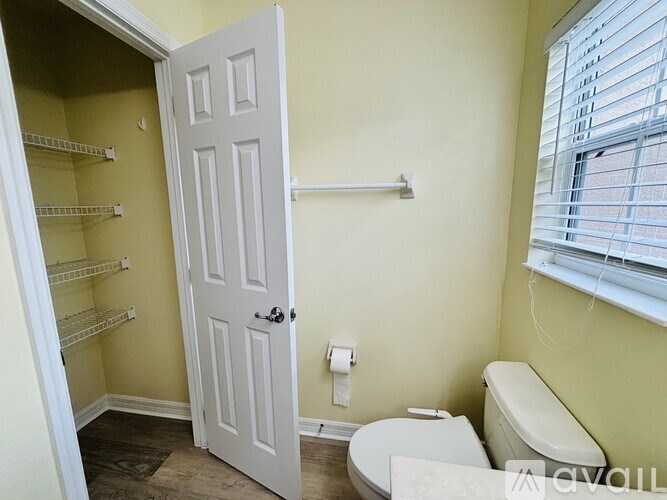 A small bathroom with a toilet, a towel rack, and a door.