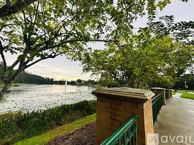 A walkway with a green railing overlooks a body of water.