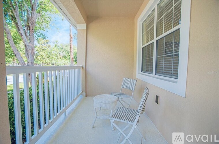 A patio with a white chair and table.