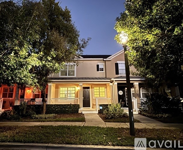 A house with a front porch and a lit-up street lamp.
