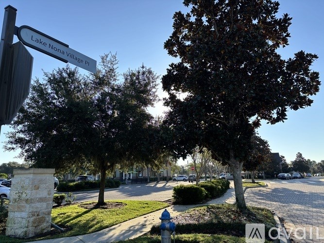 A street sign for Lake Nona Village PI stands in front of a tree.