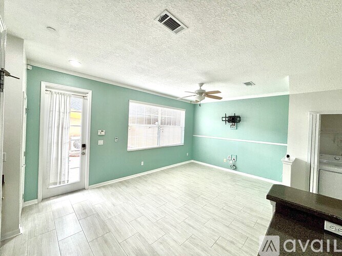 A room with a ceiling fan and a window with blinds.