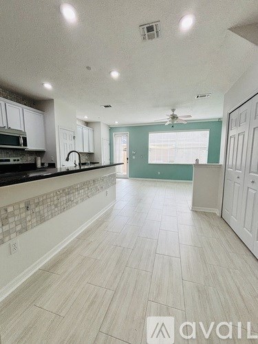A kitchen with white cabinets and a tile backsplash.