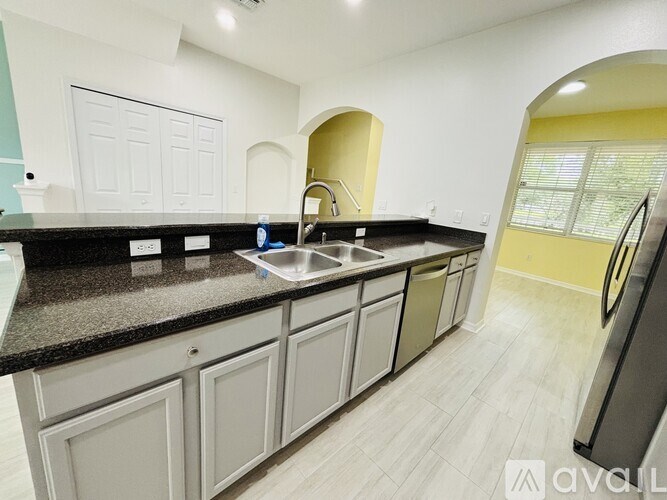 A kitchen with a black granite countertop and white cabinets.