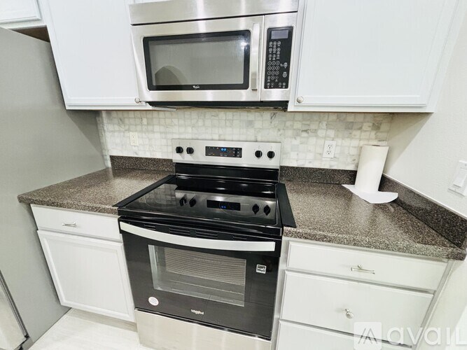 A kitchen with a stove, microwave, and oven.