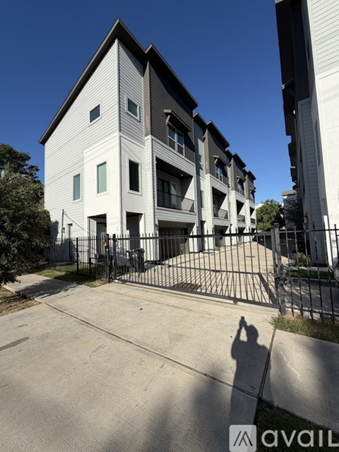 A modern two-story building with a black gate in front.