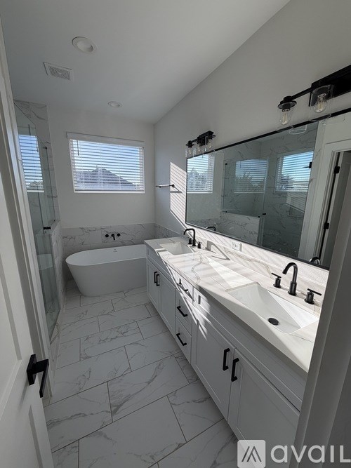 A bathroom with a tub, sink, and mirror.