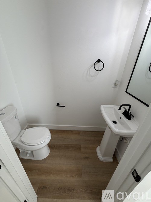A white toilet sits next to a sink in a small bathroom.