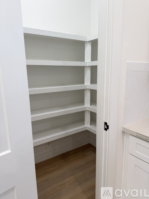 Empty white shelves in a kitchen.