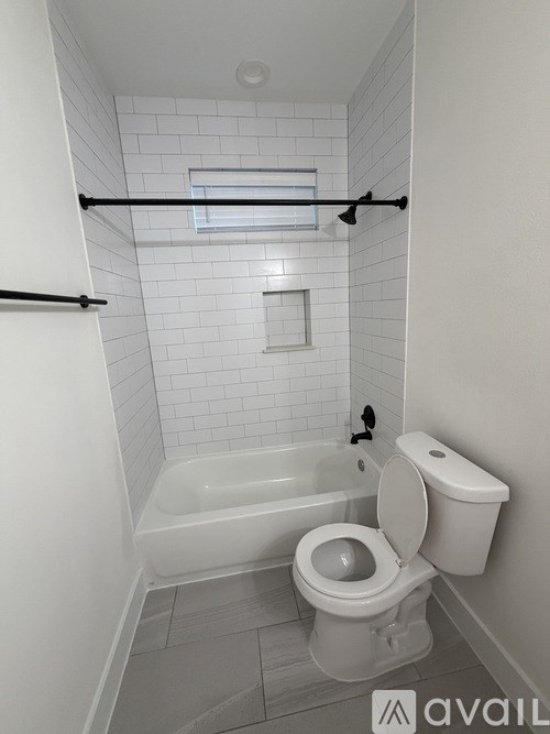A white toilet and tub in a small bathroom.