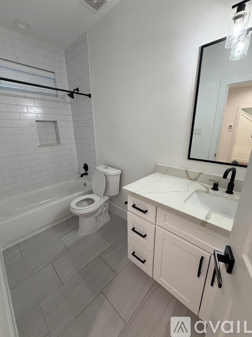 A bathroom with a toilet, sink, and bathtub.