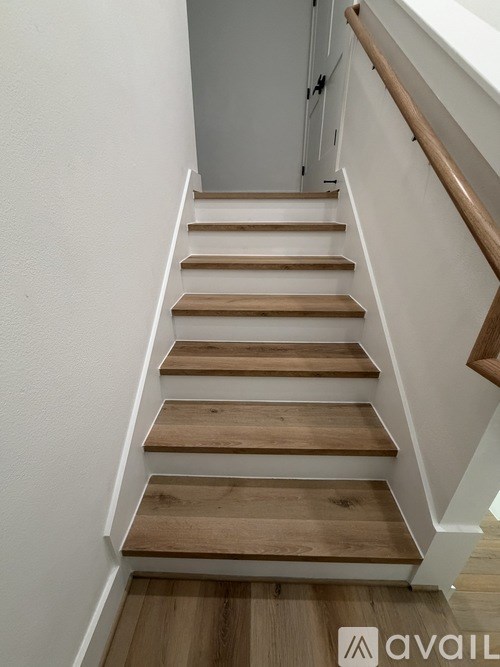 A set of wooden stairs with white risers.