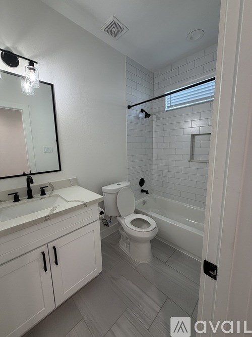 A bathroom with a toilet, sink, and mirror.