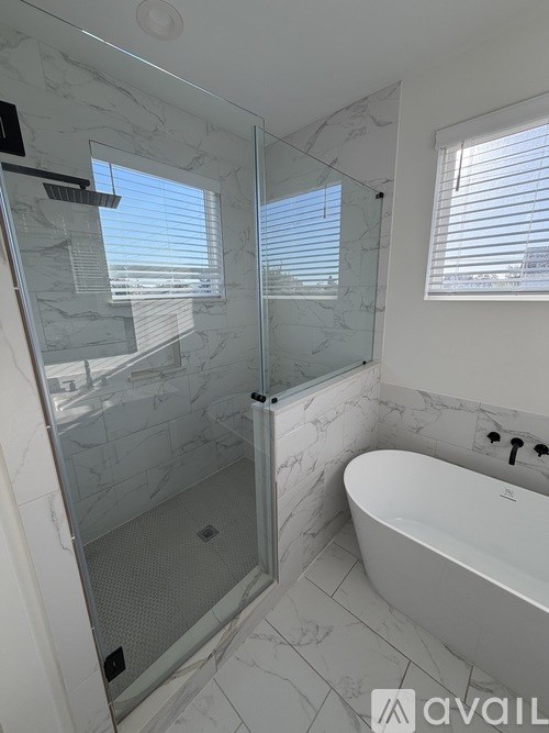 A bathroom with a marble tub and shower.