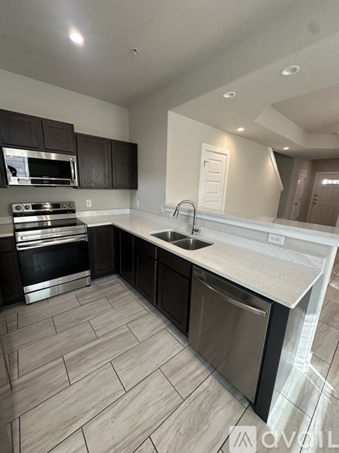 A modern kitchen with a stove top oven and a sink.