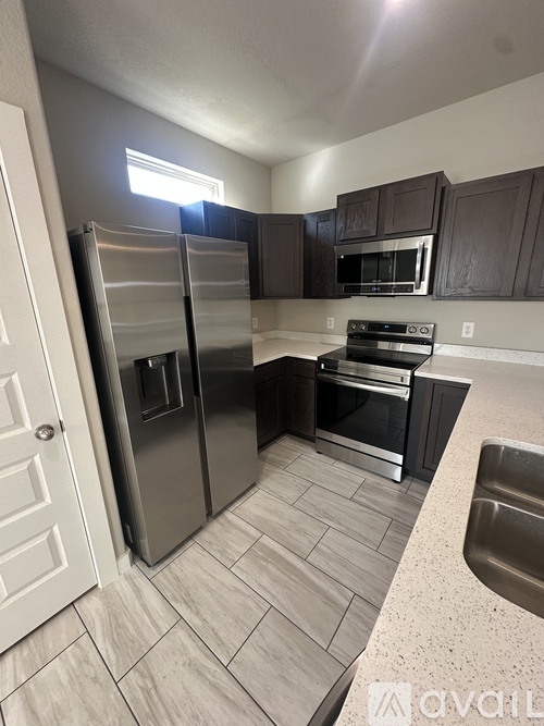 A kitchen with a stainless steel refrigerator and oven.