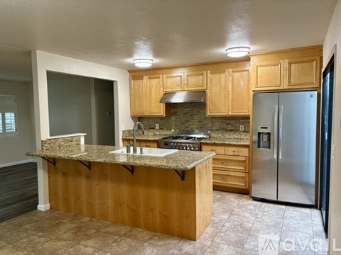 A kitchen with wooden cabinets and a granite countertop.