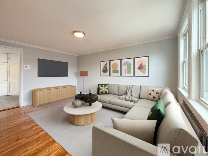 A room with wooden floors and a window with a radiator beneath it.