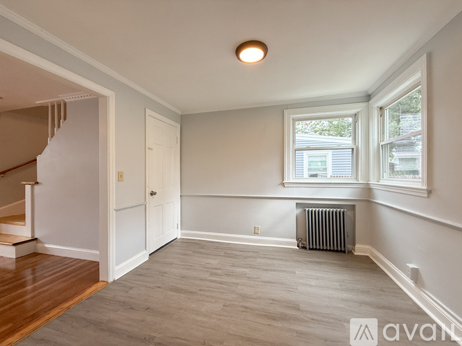 A spacious room with a window and a radiator on the floor.