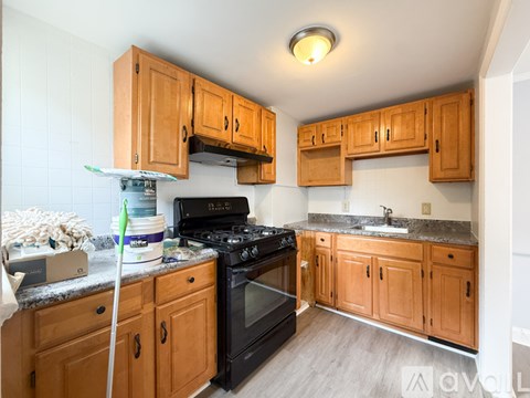 A kitchen with wooden cabinets and a black stove top oven.