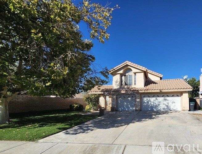 A house with a garage and a tree in front of it.