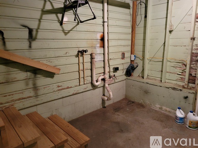 A room with a white wall and a pipe running along it.