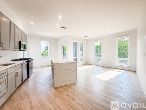 A spacious kitchen with wooden floors and a large island in the middle.