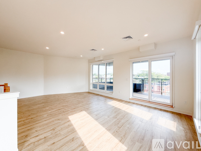 A large empty room with wooden floors and white walls.