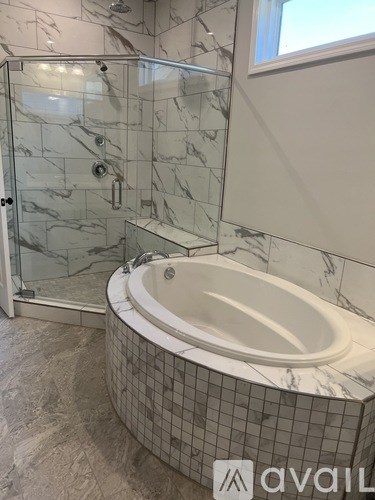 A bathroom with a marble tub and shower.