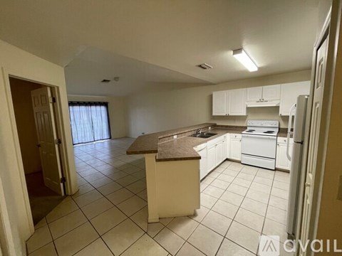 A kitchen with white appliances and a brown island.