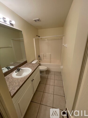 A bathroom with a sink, mirror, and toilet.