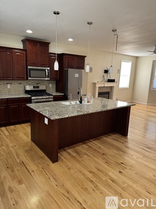 A kitchen with a granite countertop and wooden cabinets.