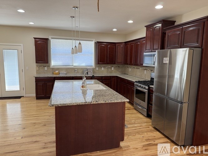 A kitchen with a granite countertop and stainless steel appliances.