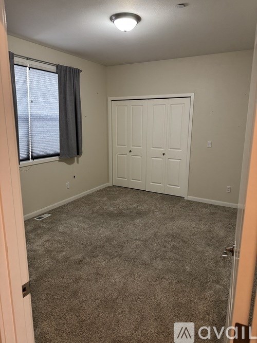 A room with a white door and carpeted floor.