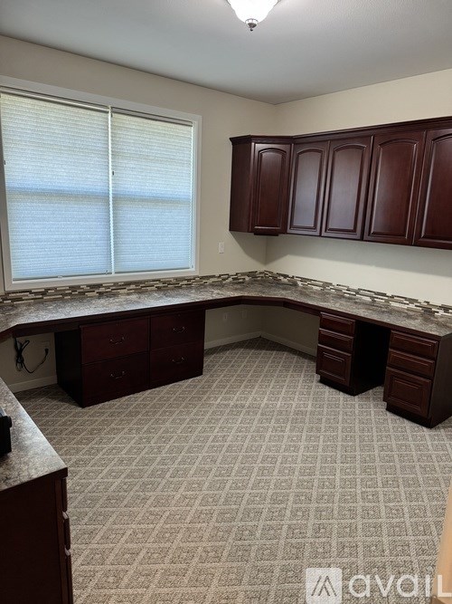 A room with a desk and drawers in it.