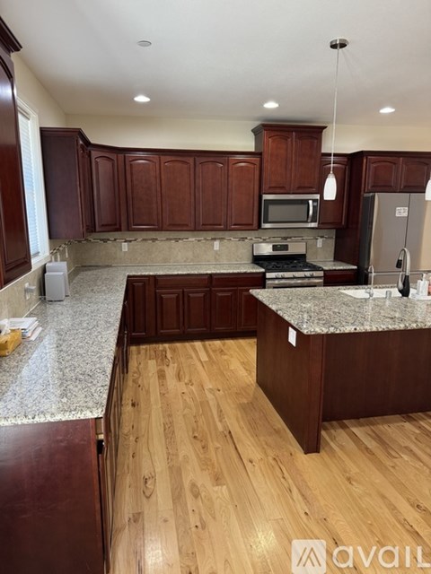 A kitchen with wooden cabinets and a granite countertop.