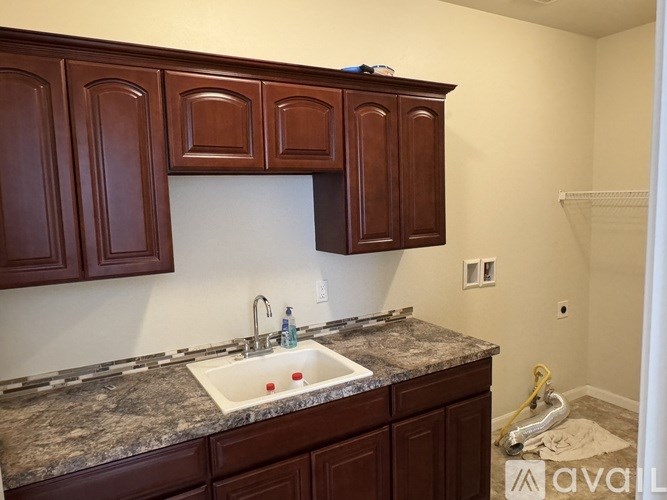 A kitchen with brown cabinets and a granite countertop.