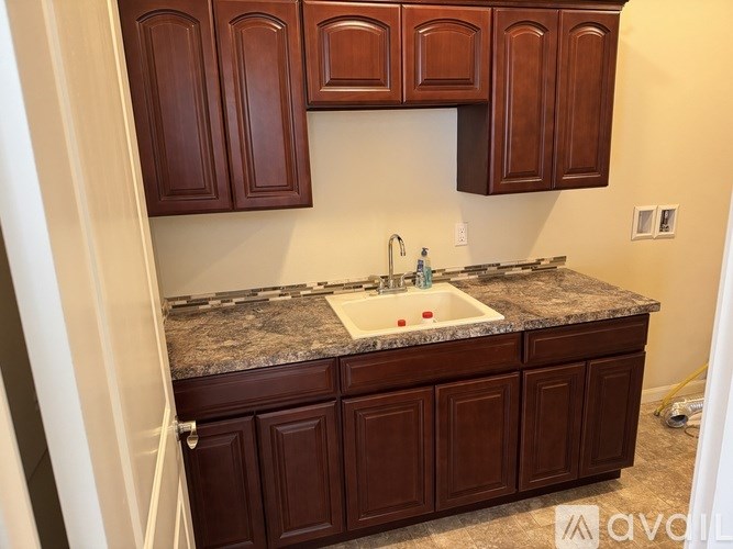 A kitchen with brown cabinets and granite countertops.