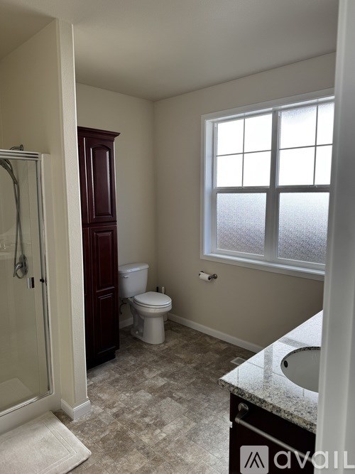 A bathroom with a toilet, sink, and shower.