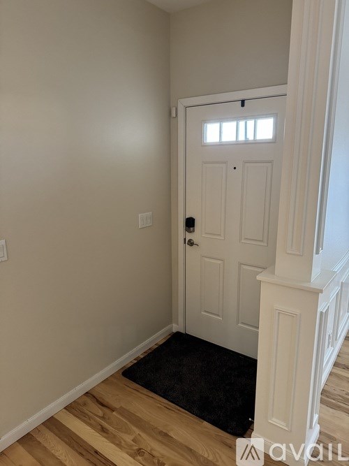 A white door with a black mat in front of it.