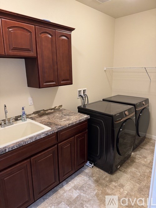 A room with a carpeted floor, a ceiling fan, and a window with blinds.