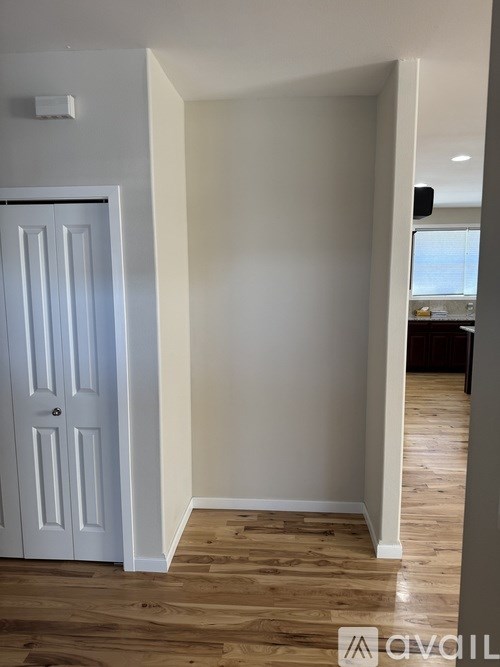 A white door is in a room with wood flooring.