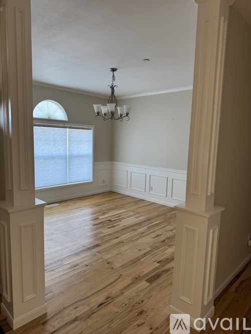 A room with wooden floors and a chandelier.