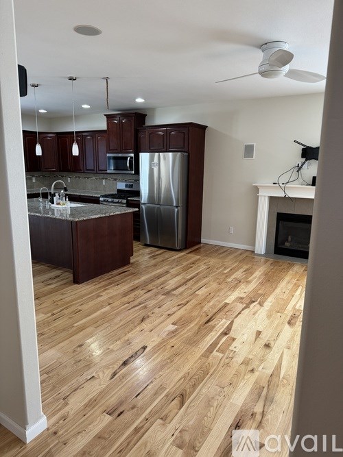 A kitchen with wooden floors and a refrigerator.