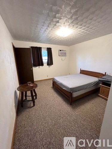 A bedroom with a bed, desk, and chair.