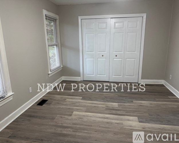 A room with a white door and a window with blinds.