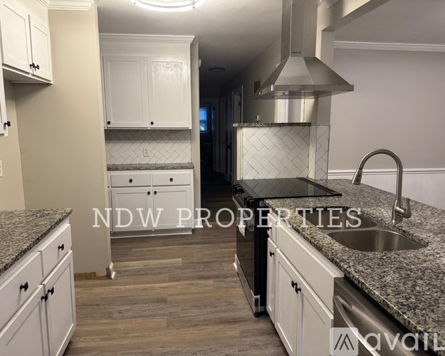 A kitchen with a granite countertop and a stainless steel sink.